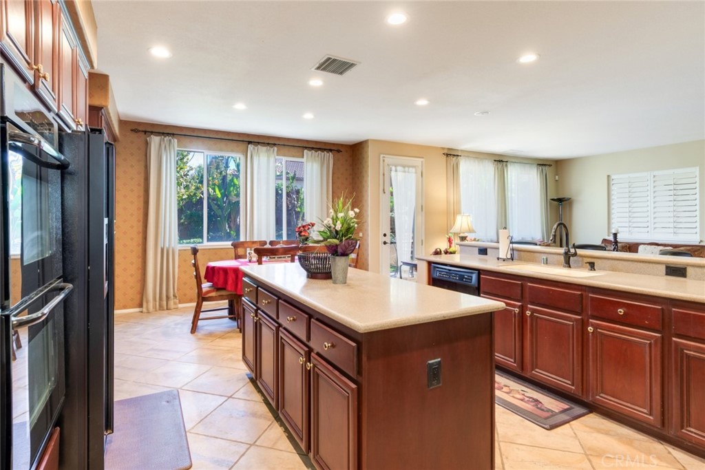 2967 Mangular Avenue Corona, CA 92882 - Photo 17 of 37 a kitchen with kitchen island granite countertop a sink stove and cabinets
