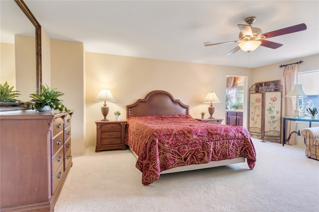 2967 Mangular Avenue Corona, CA 92882 - Photo 19 of 37 a spacious bedroom with a bed and a chandelier