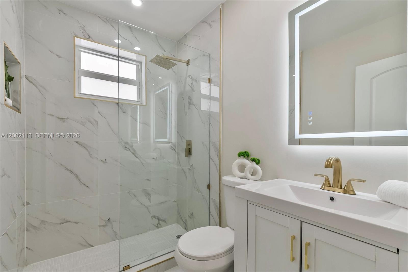 1852 Southwest 22nd Terrace, Unit 2 Miami, FL 33145 - Photo 11 of 20 a bathroom with a granite countertop sink toilet a mirror and shower