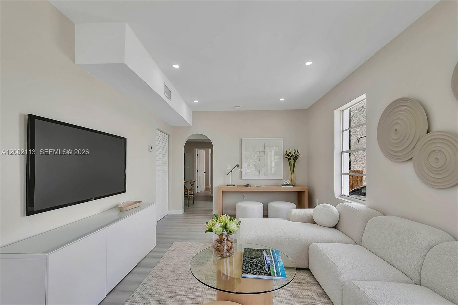 1852 Southwest 22nd Terrace, Unit 2 Miami, FL 33145 - Photo 2 of 20 a living room with furniture a mirror and a flat screen tv
