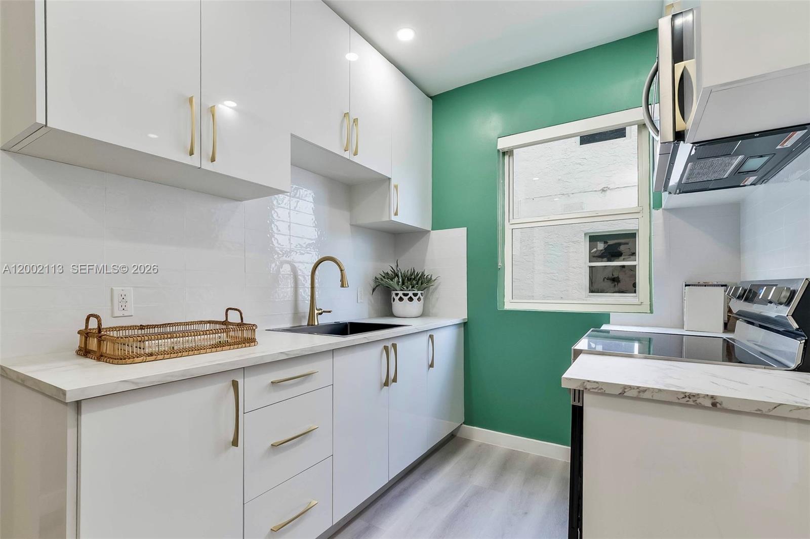 1852 Southwest 22nd Terrace, Unit 2 Miami, FL 33145 - Photo 8 of 20 a kitchen with sink refrigerator and cabinets