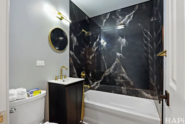 a bathroom with a sink vanity mirror and toilet