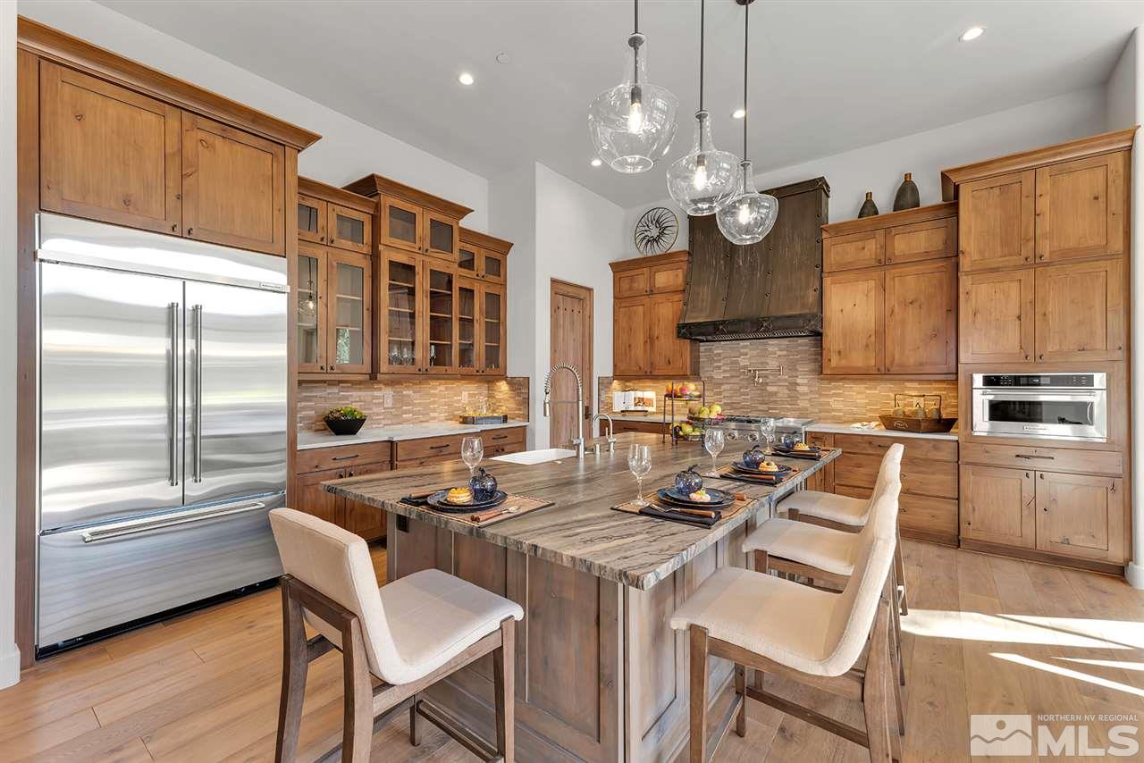 249 Mill Race Loop Carson City, NV 89705 - Photo 11 of 40 a kitchen with granite countertop a stove a sink a dining table and chairs