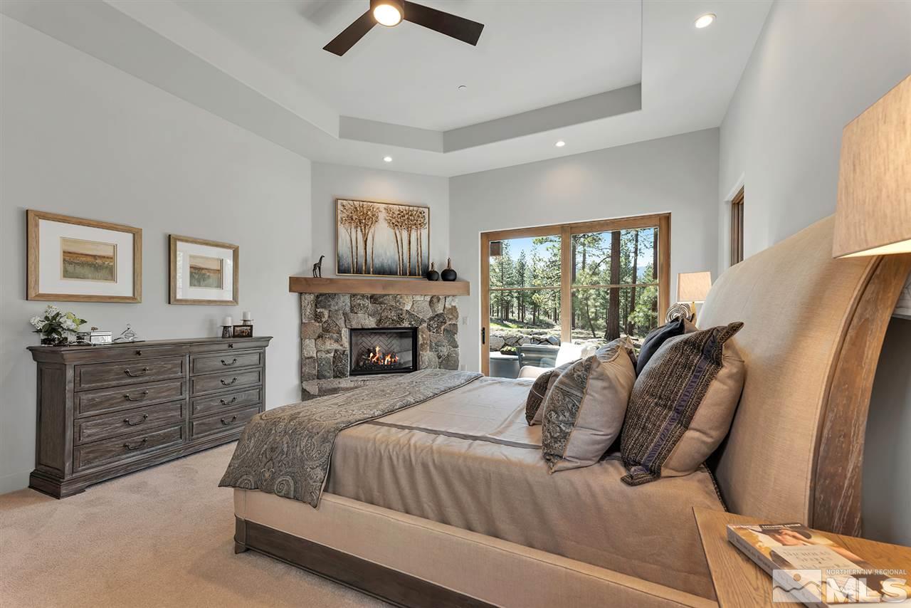 249 Mill Race Loop Carson City, NV 89705 - Photo 16 of 40 a spacious bedroom with a large bed and a fireplace