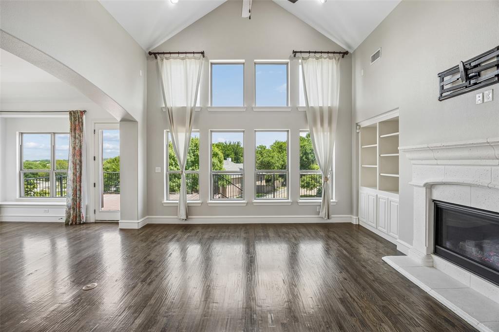 134 Santa Rosa Way Irving, TX 75062 - Photo 9 of 26 Light-filled living room with soaring ceilings, wood floors, and seamless connection to the outdoor living space.
