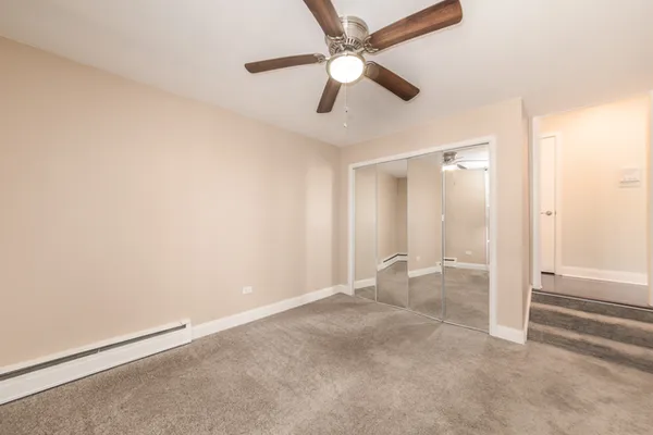 an empty room with closet and windows