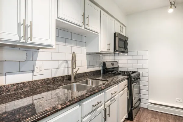 a kitchen with stainless steel appliances granite countertop a sink stove and cabinets