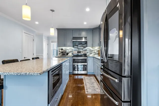 a kitchen with kitchen island granite countertop appliances cabinets and a sink