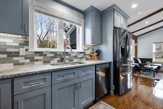 a kitchen with granite countertop stainless steel appliances a sink stove and cabinets