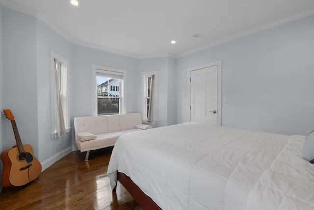 a bedroom with a bed and wooden floor