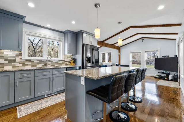 a kitchen with granite countertop a stove a sink and a refrigerator