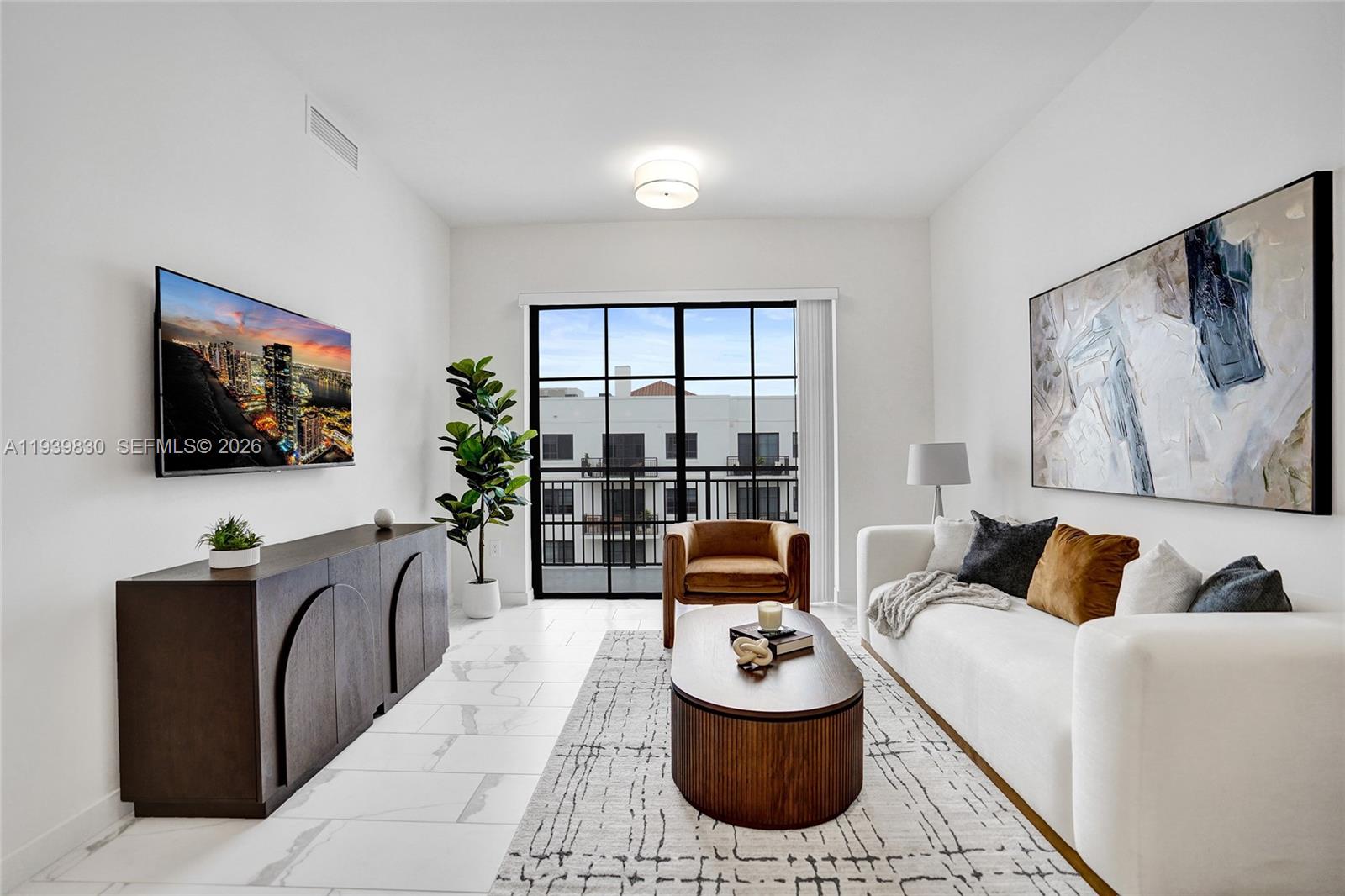 101 East Camino Real, Unit PH07 Boca Raton, FL 33432 - Photo 37 of 43 a living room with furniture a flat screen tv and a floor to ceiling window