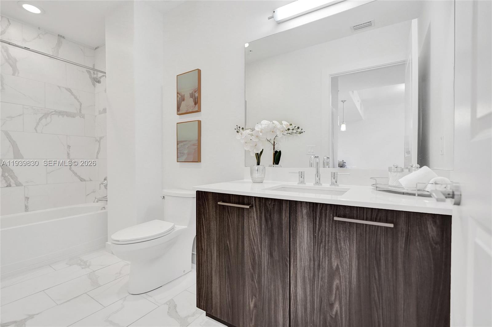 101 East Camino Real, Unit PH07 Boca Raton, FL 33432 - Photo 40 of 43 a bathroom with a sink a toilet and a large mirror