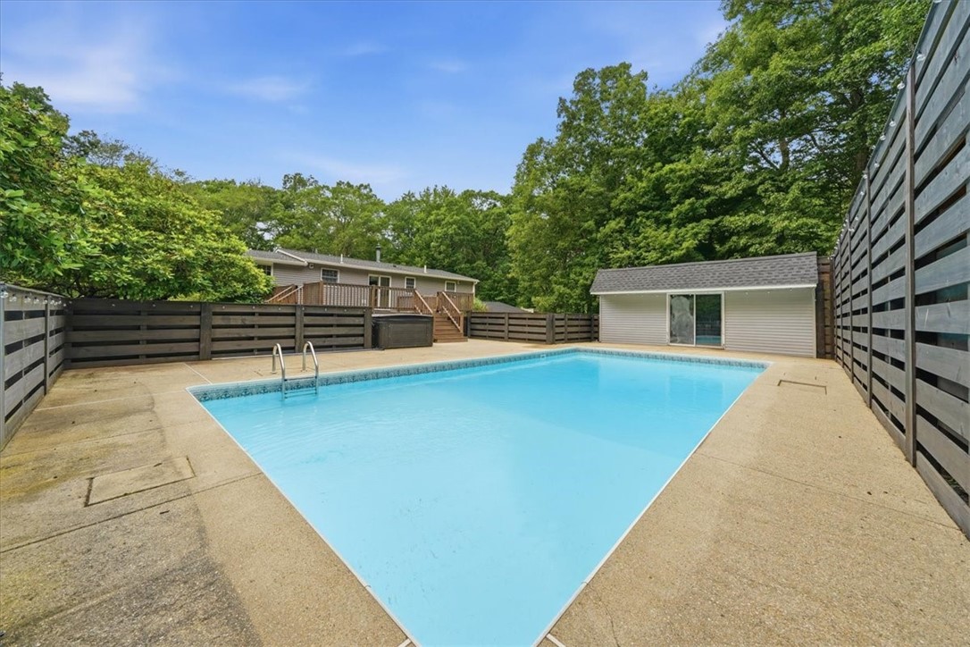 214 Anan Wade Road Glocester, RI 02857 - Photo 37 of 50 The backyard is centered around a 17' x 35' in-ground saltwater pool, surrounded by expansive patio space for sunbathing, seating, and summer entertaining.