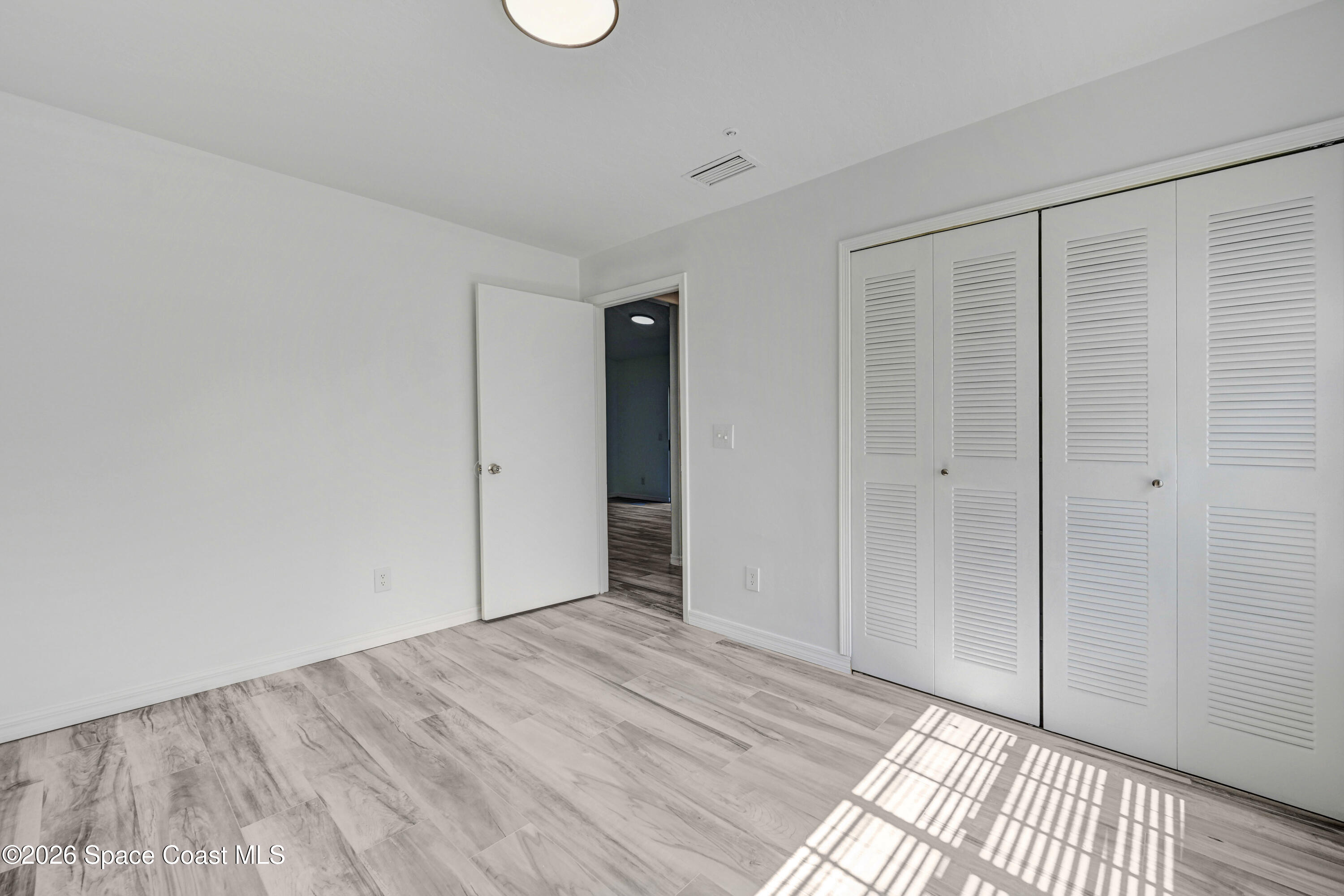 7667 North Wickham Road, Unit 1309 Melbourne, FL 32940 - Photo 11 of 21 a view of an empty room with wooden floor