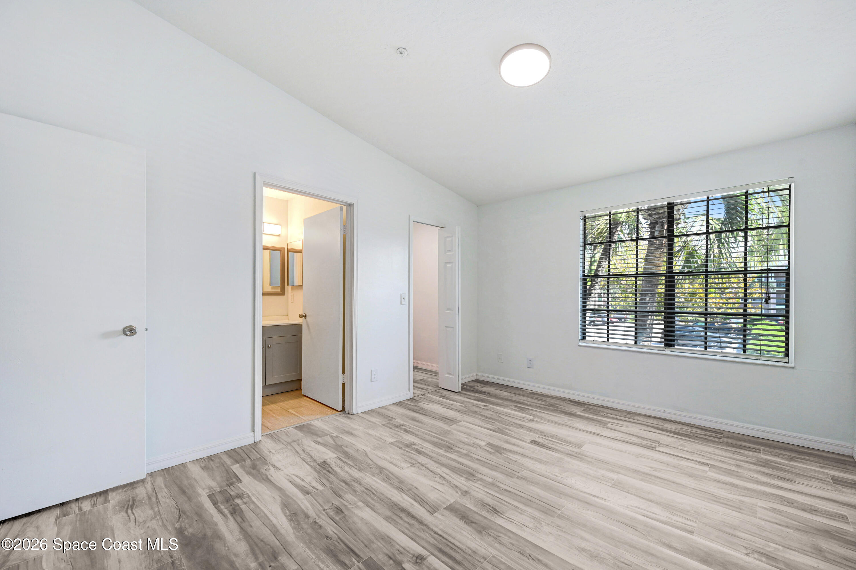 7667 North Wickham Road, Unit 1309 Melbourne, FL 32940 - Photo 21 of 21 an empty room with wooden floor and windows