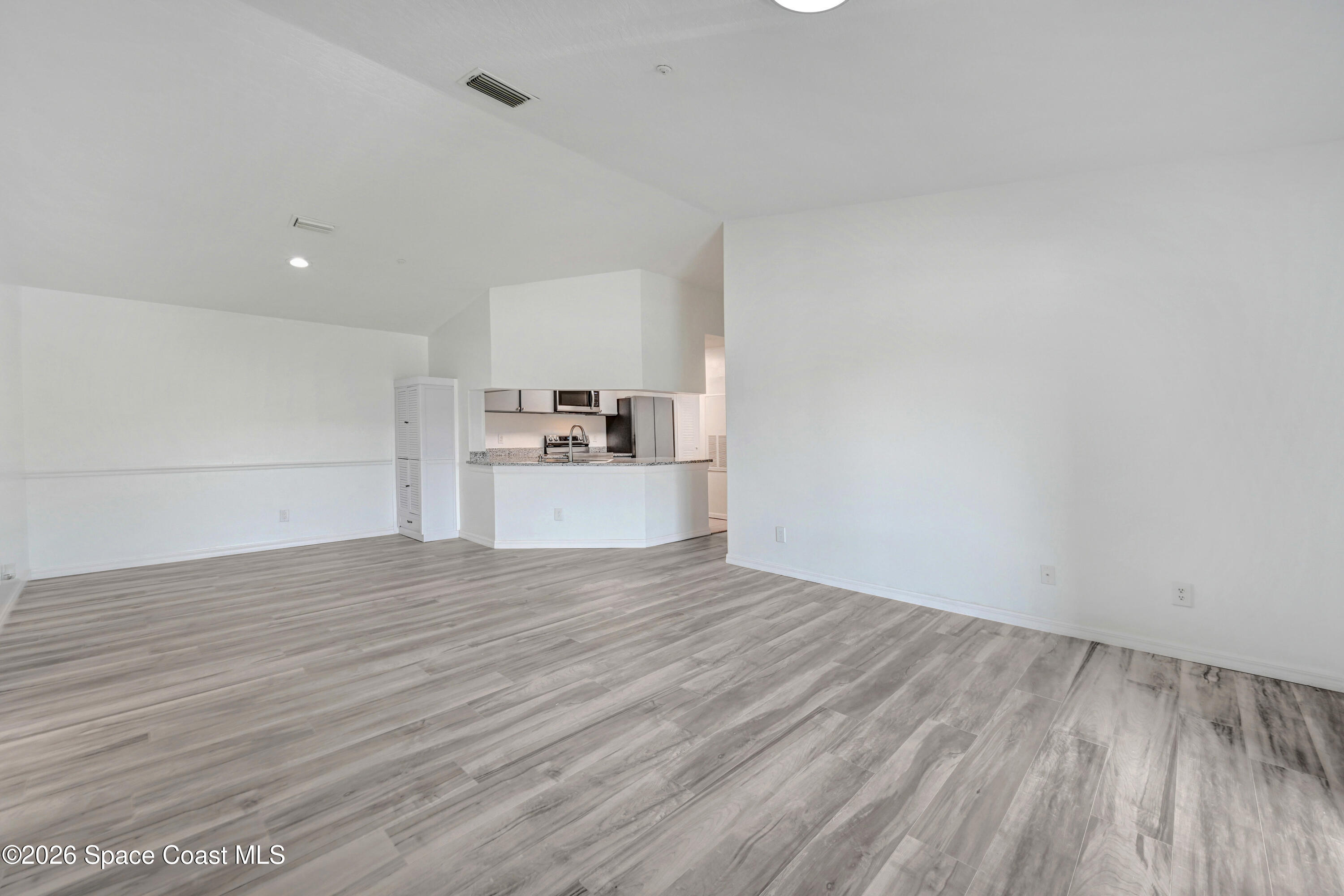 7667 North Wickham Road, Unit 1309 Melbourne, FL 32940 - Photo 7 of 21 a view of a kitchen with wooden floor and electronic appliances