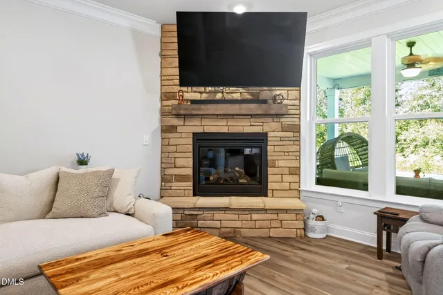 a living room with furniture a fireplace and a flat screen tv