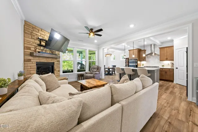 a kitchen with stainless steel appliances a dining table chairs and wooden floor
