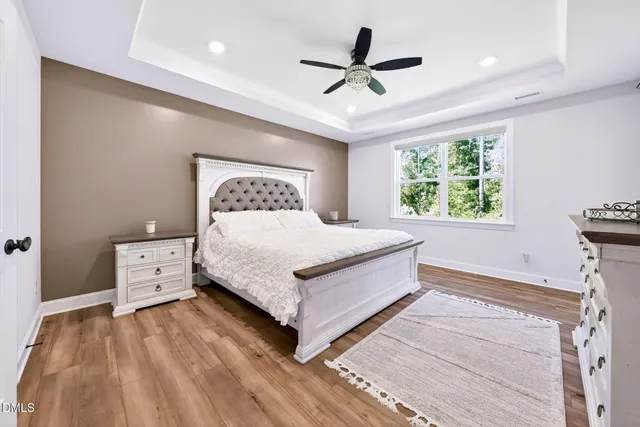 a spacious bedroom with a bed and a large mirror