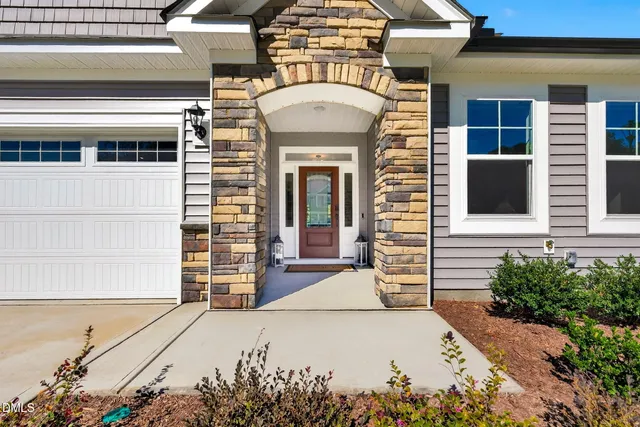 a front view of a house with a garden