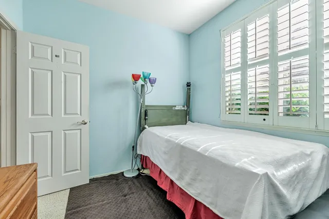 a bedroom with a bed and a large window