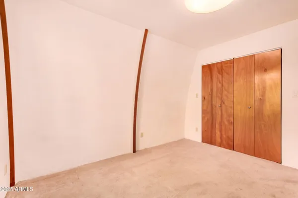 a view of a bedroom with wooden floor and windows