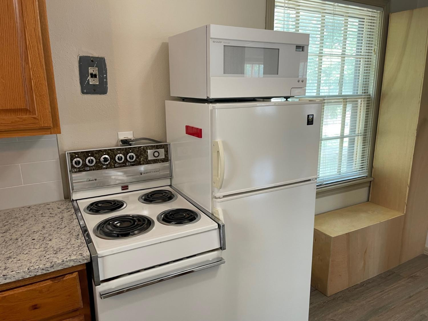 3018 29th Street Lubbock, TX 79410 - Photo 13 of 14 a white refrigerator freezer and a stove sitting inside of a kitchen