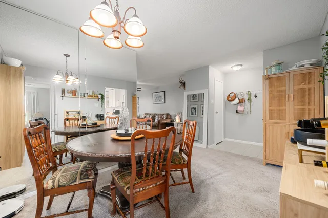 a view of a dining room and livingroom with furniture wooden floor and a chandelier