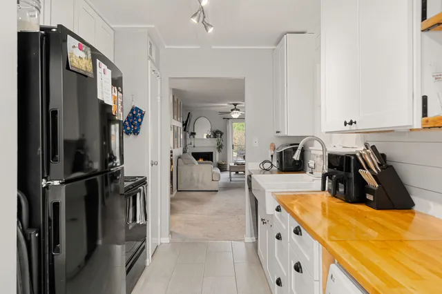 a kitchen with refrigerator a sink and white cabinets