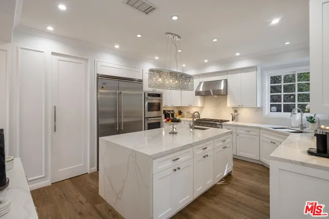 a kitchen with a sink stainless steel appliances and white cabinets