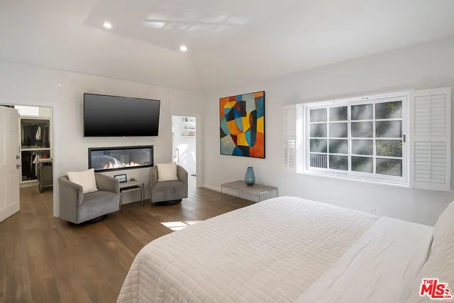 a bedroom with furniture and a flat screen tv