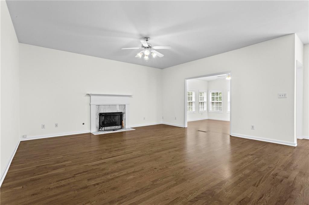 4282 Goldfield Trace, Unit MAIN & 2 Suwanee, GA 30024 - Photo 7 of 28 an empty room with wooden floor chandelier fan and windows