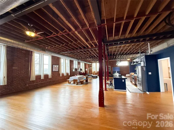 a view of a livingroom with furniture wooden floor and a kitchen