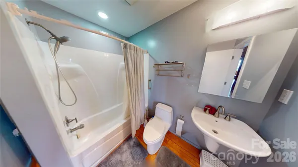 a bathroom with a tub sink and mirror