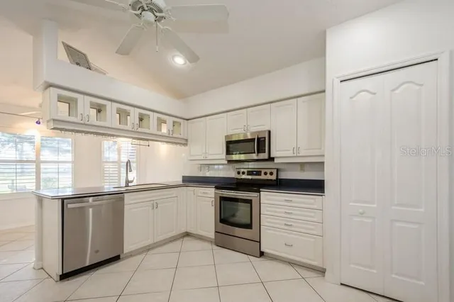a kitchen with white cabinets and white stainless steel appliances