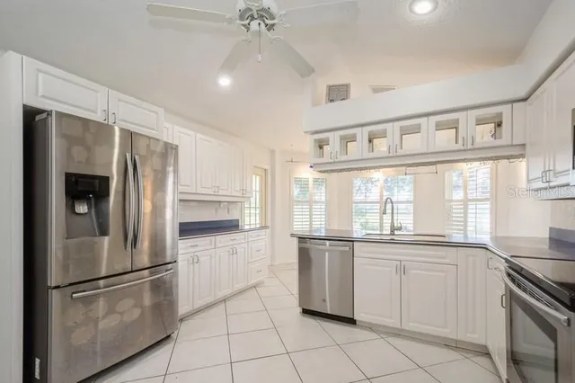 a kitchen with stainless steel appliances a refrigerator sink and cabinets