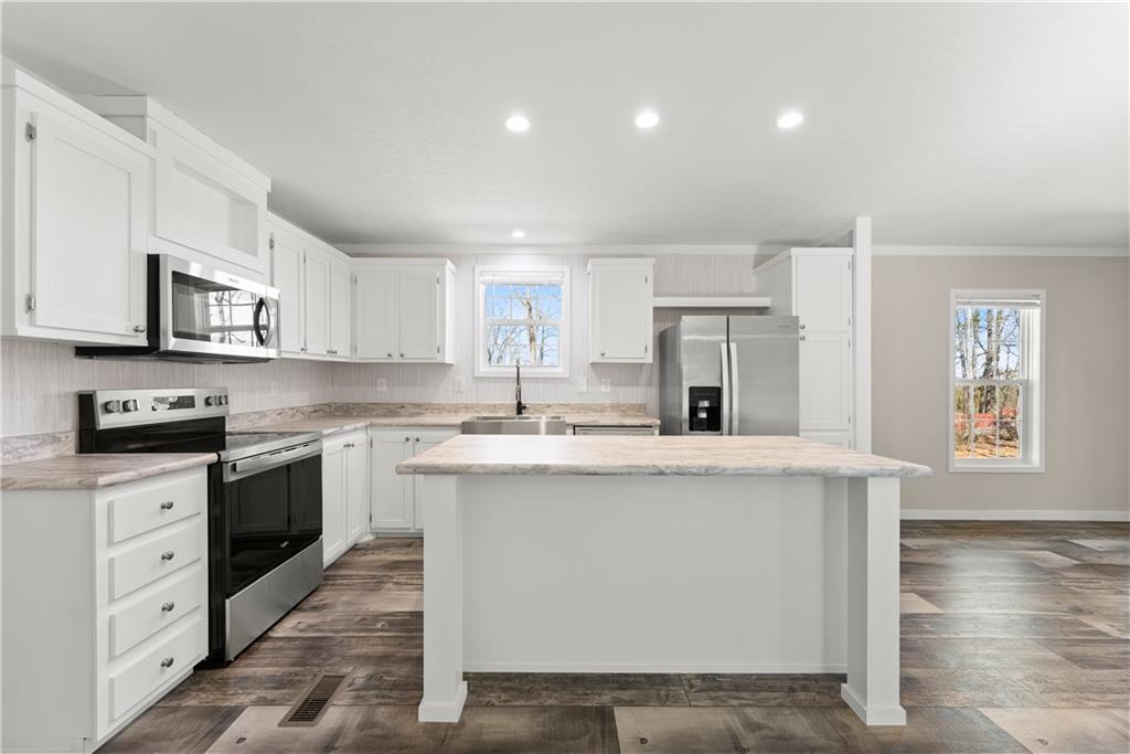 2410 Bolman Road Gainesville, GA 30507 - Photo 9 of 32 a kitchen with stainless steel appliances granite countertop a white stove top oven a sink dishwasher and a refrigerator with wooden floor