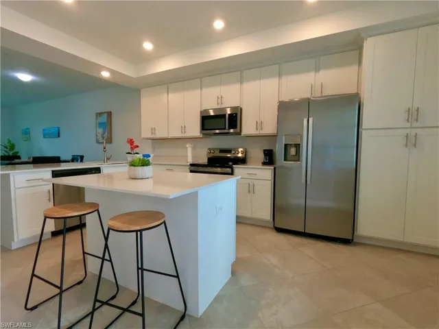 a kitchen with stainless steel appliances a refrigerator a stove a sink and a refrigerator