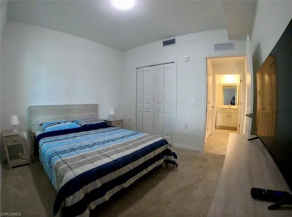 a bedroom with a bed and a large mirror
