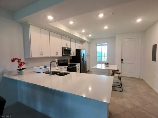 a kitchen with sink refrigerator and microwave