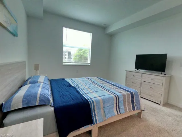 a bedroom with a bed and flat screen tv