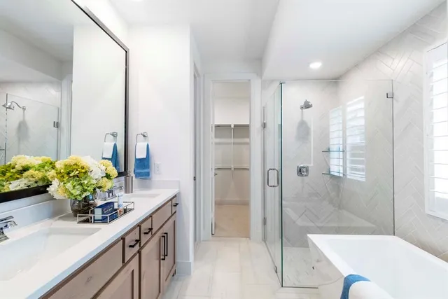a bathroom with a sink mirror and shower