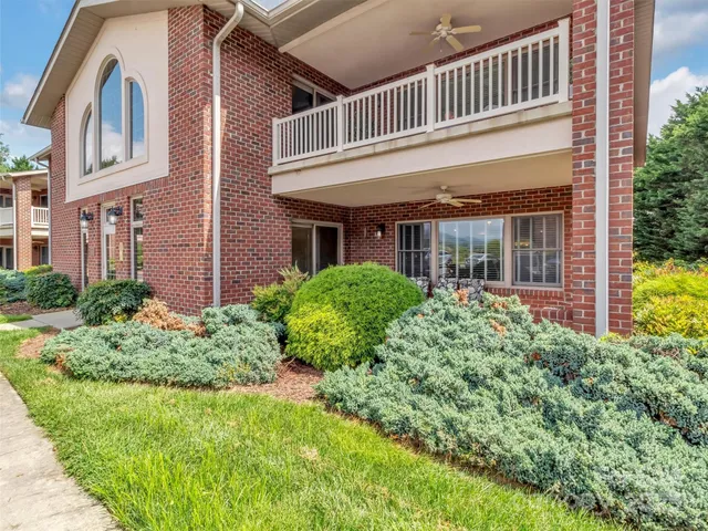 a view of a house with brick walls and flower plants