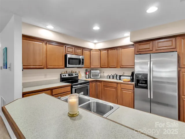 a kitchen with granite countertop a sink stainless steel appliances and cabinets