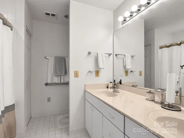 a en suite bathroom with a sink vanity and mirror