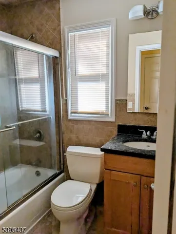 a bathroom with a granite countertop toilet a sink and a bathtub