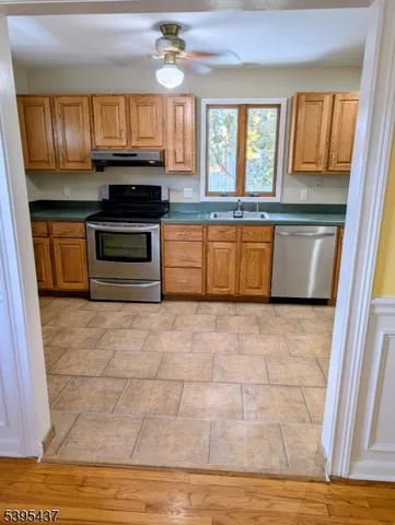 a kitchen with granite countertop a stove a sink and a microwave