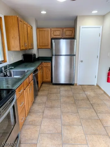 a kitchen with granite countertop a refrigerator a sink and dishwasher