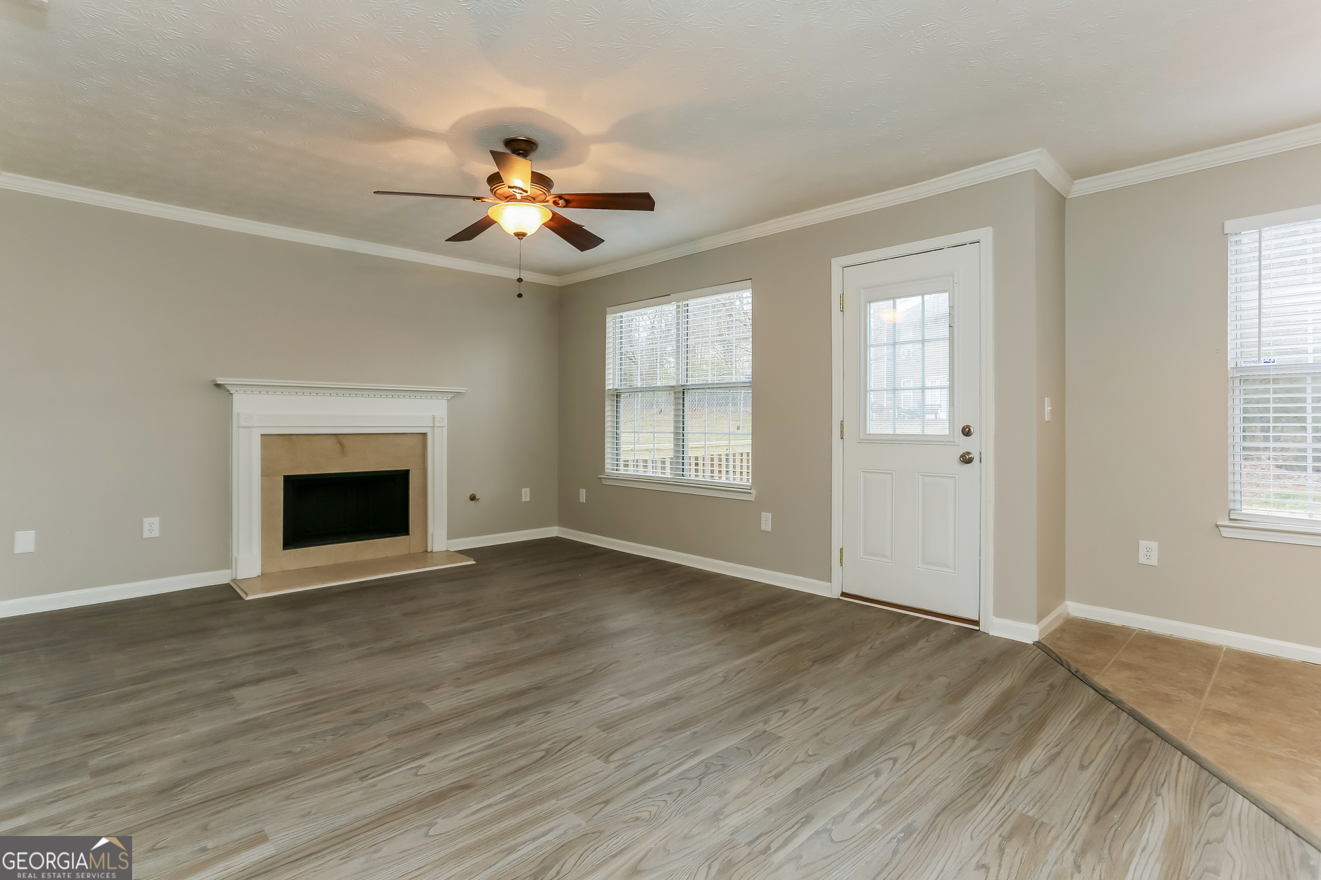 3797 Landgraf Cove Decatur, GA 30034 - Photo 2 of 17 an empty room with wooden floor chandelier fan and windows
